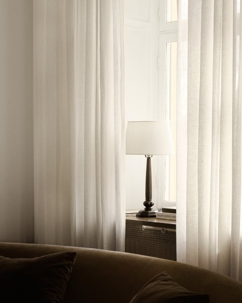Neutral sheer curtains styled in a minimalist dining room