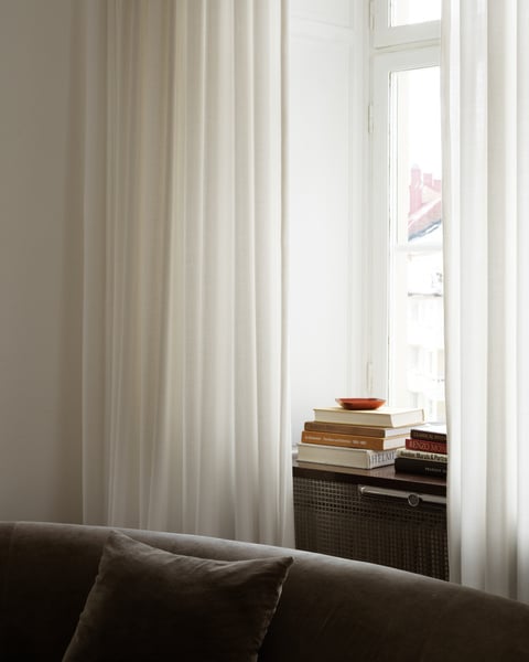 White sheer curtains hanging in a bright living room window